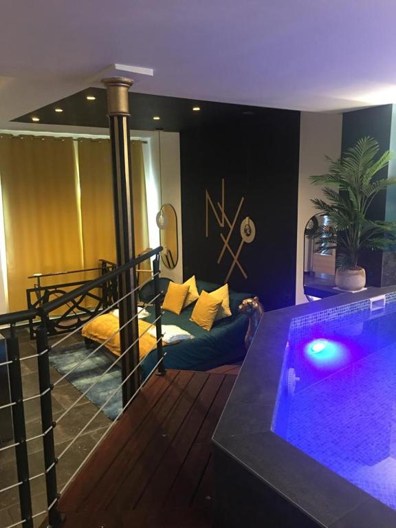 sala de estar con bañera de hidromasaje en una habitación en Nyx suite d’exception, en Dijon