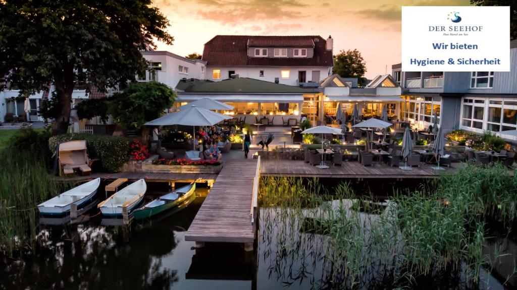 ein Restaurant neben einem Yachthafen mit Booten im Wasser in der Unterkunft Hotel Der Seehof in Ratzeburg