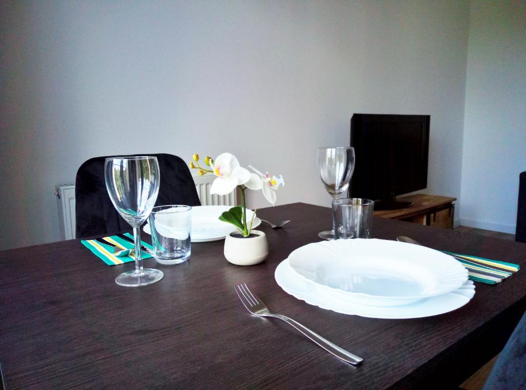 einem Holztisch mit Teller und Gläsern darauf in der Unterkunft Apartamenty Garbary Loft in Posen