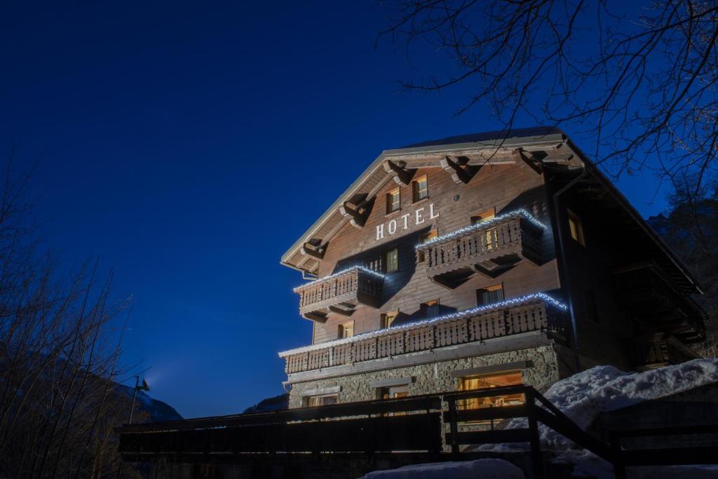 un edificio con un cartel de hotel por la noche en Hotel Rascard en Valtournenche