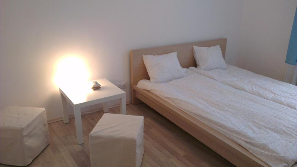 1 dormitorio con 1 cama y 1 mesa con lámpara en Apartman 4 you, en Budapest