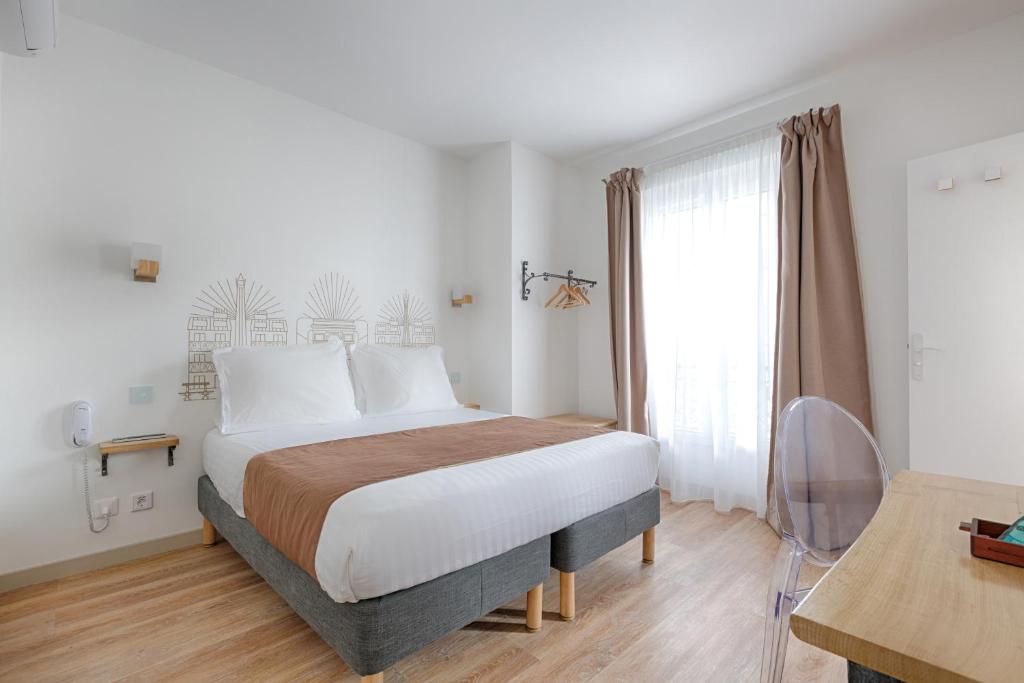 a bedroom with a bed and a large window at Hôtel Korner Etoile in Paris