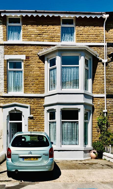 a car parked in front of a brick house at Delamere holiday flat in Blackpool