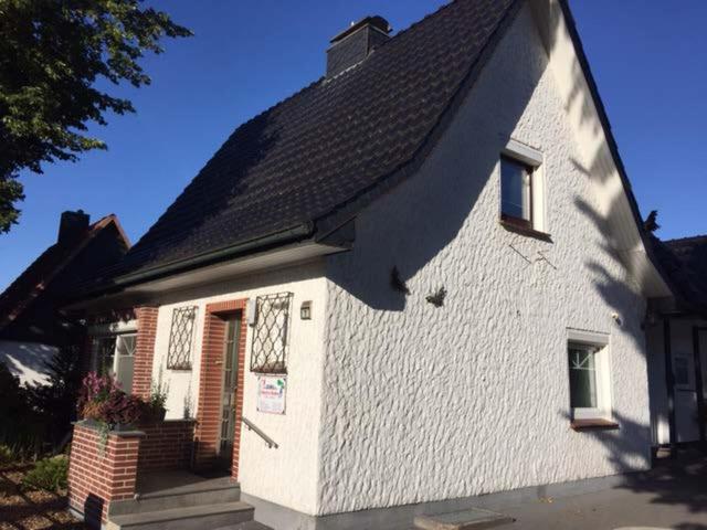 une maison blanche avec un toit noir dans l'établissement Ferienwohnung Runge, à Schneverdingen