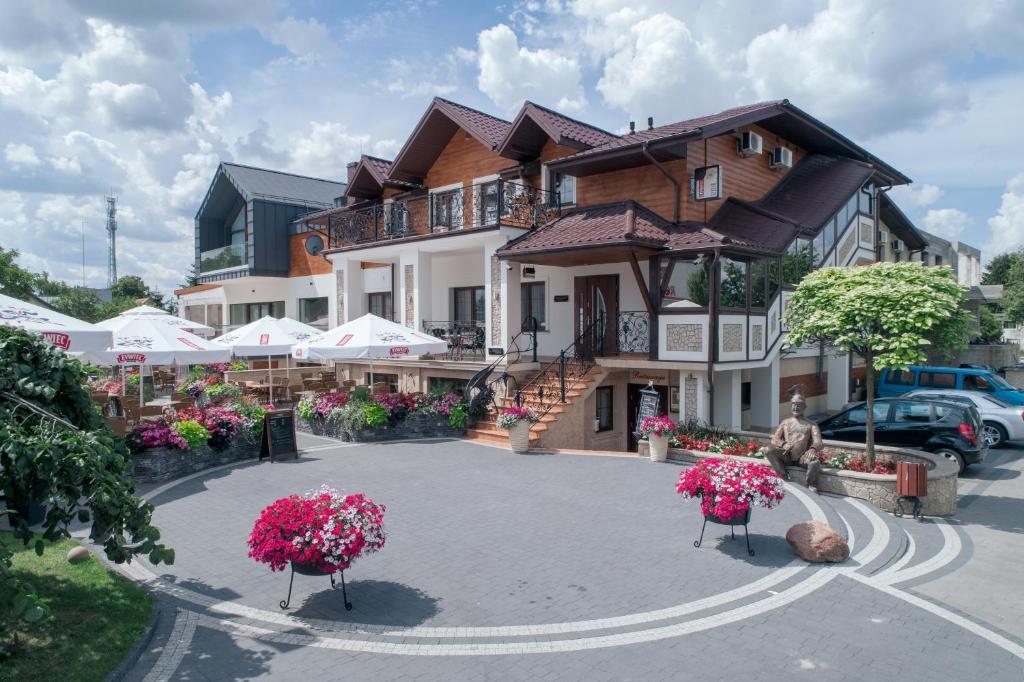 un gran edificio con flores delante en Hotel & Restauracja Gniecki, en Hrubieszów