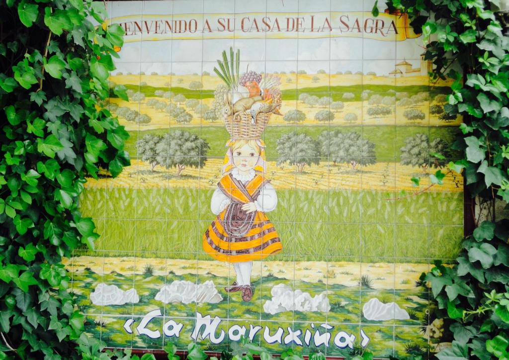 Hotel La Maruxiña في La Alameda de la Sagra: جدار فيه صورة لفتاة تمسك الدجاج