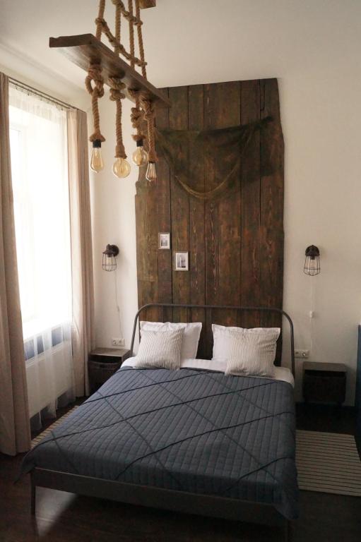 a bedroom with a bed with a large wooden headboard at DABA Mini Hotel in Riga