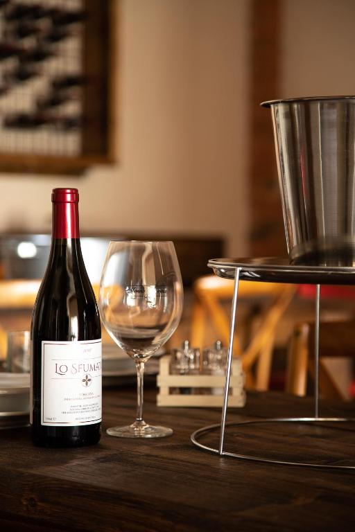 a bottle of wine and a glass on a table at Monna Caterina Wine Resort in Vinci