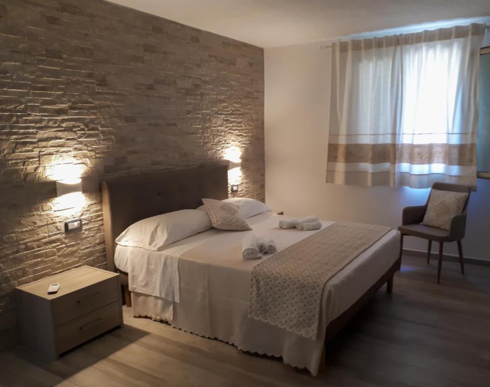 a bedroom with a large bed and a brick wall at Il Lentischio in Cala Gonone
