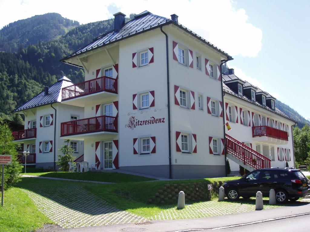 ein großes weißes Gebäude mit einem Auto vor dem Haus in der Unterkunft Kitz Residenz Appartement 10 Kaprun in Kaprun