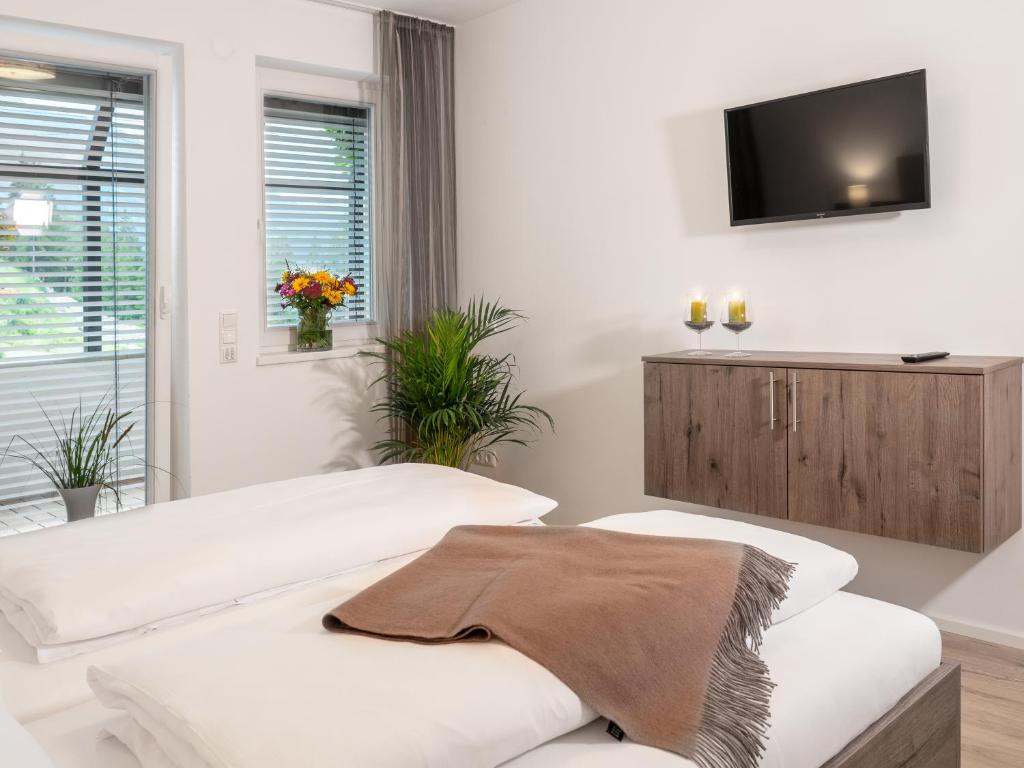 ein weißes Wohnzimmer mit einem TV an der Wand in der Unterkunft Appartement Burgblick in Heinfels