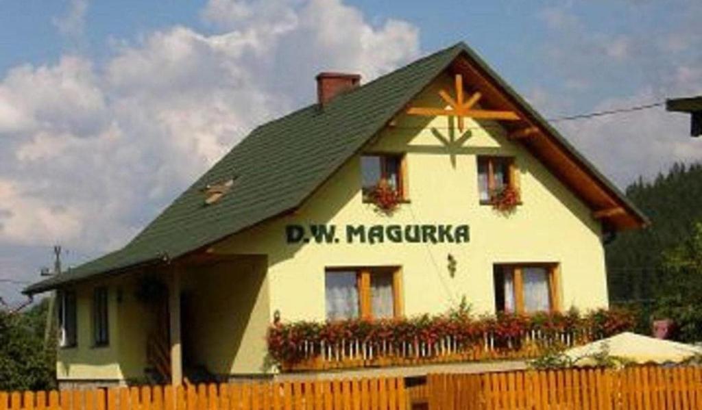 ein Haus mit einem grünen Dach und einem Zaun in der Unterkunft D.W MAGURKA in Rycerka Górna