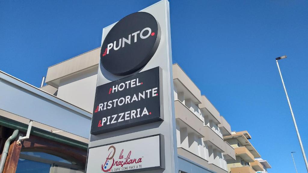 un cartello di fronte a un edificio con un cartello di puma di HOTELRISTORANTE IL PUNTO a Marotta