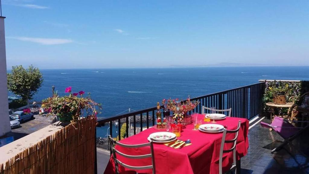 a table with a red table cloth on a balcony at Blue Oasis in Piano di Sorrento