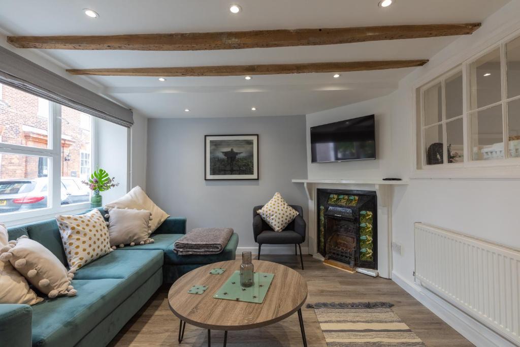 a living room with a blue couch and a table at Lion Cottage in Holt