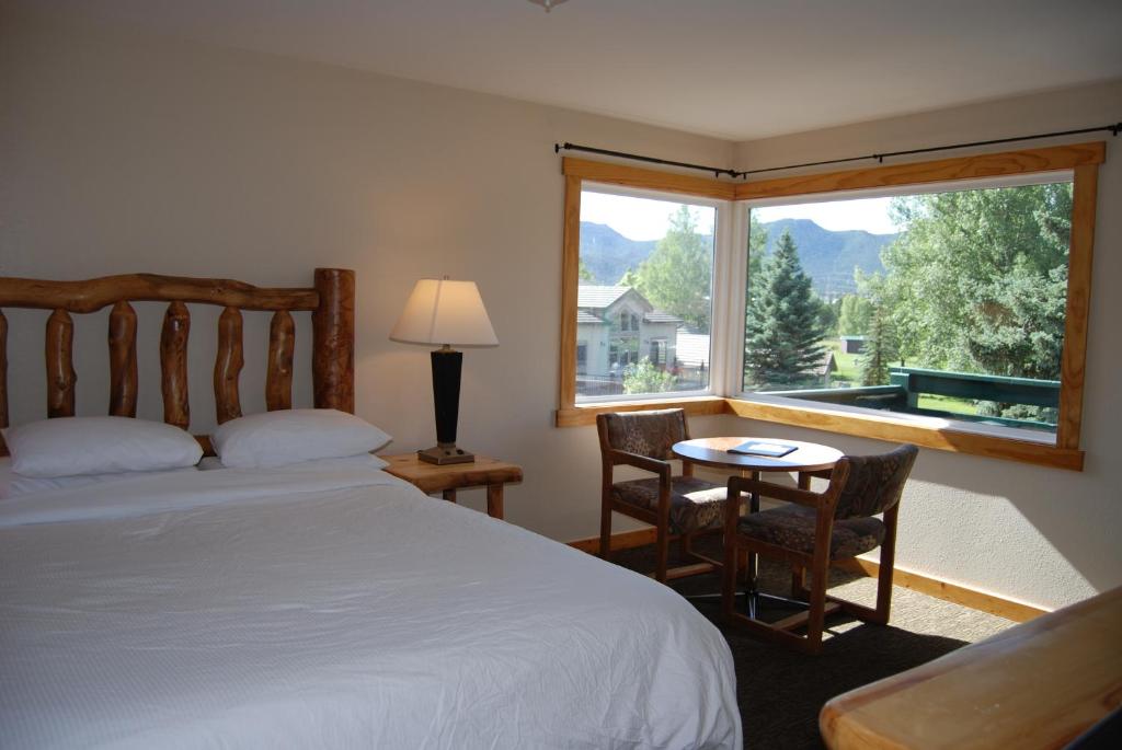 
a bedroom with a bed and a table at Discovery Lodge in Estes Park
