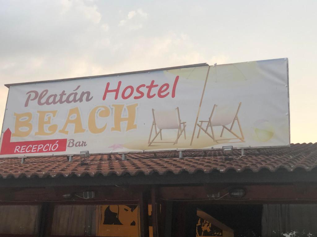 un panneau indiquant un bar de plage avec trois chaises sur le toit dans l'établissement Beach Hostel Balatonboglár, à Balatonboglár