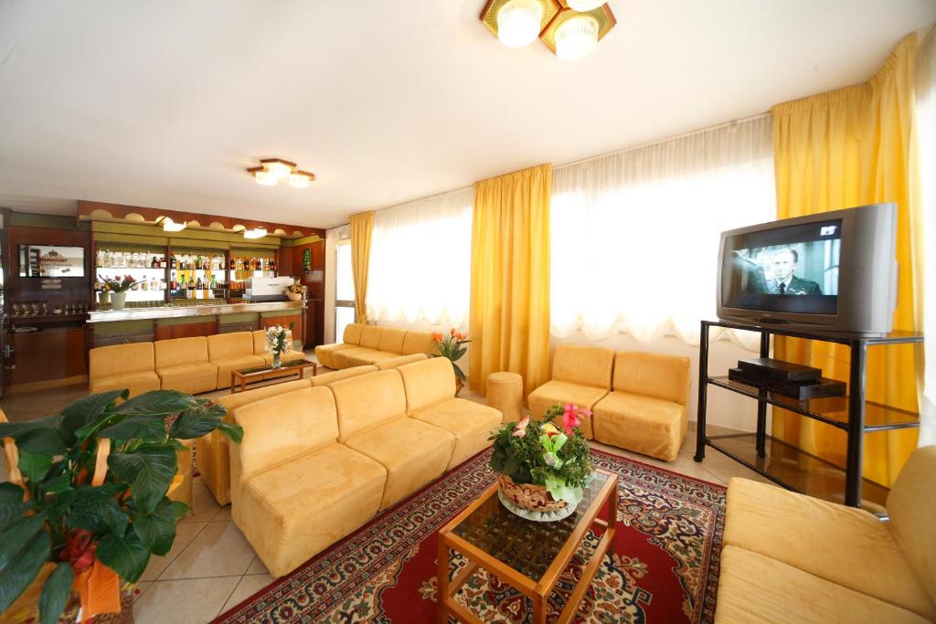 salon z kanapą i telewizorem w obiekcie Hotel Devon Rooms & Breakfast w Cesenatico