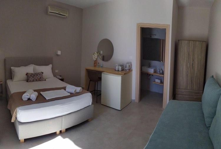 1 dormitorio con cama y escritorio. en Galini Apartment's-Suites en Skalotí