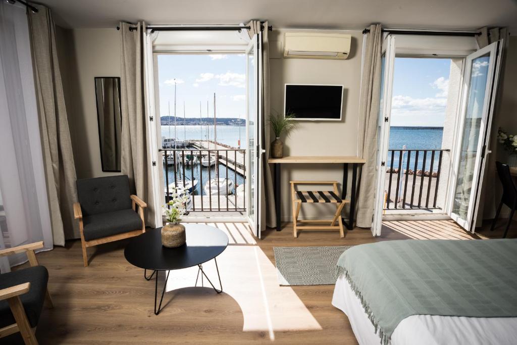 a bedroom with a bed and a view of the ocean at A La Voile Blanche in Bouzigues