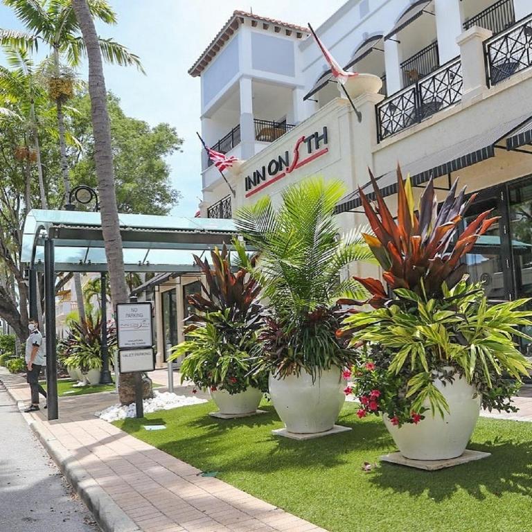 a hotel with several large pots of plants in front of it at Inn On Fifth in Naples