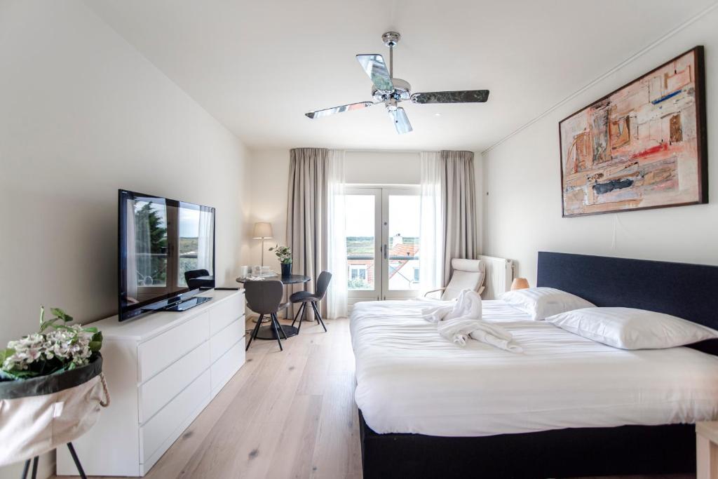 1 dormitorio con 1 cama grande y TV en Keller Beach, en Zandvoort
