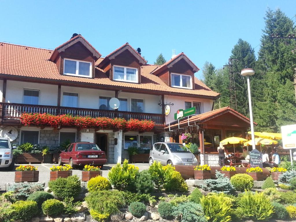 a large building with cars parked in front of it at Penzion Pod Boubínem in Kubova Huť