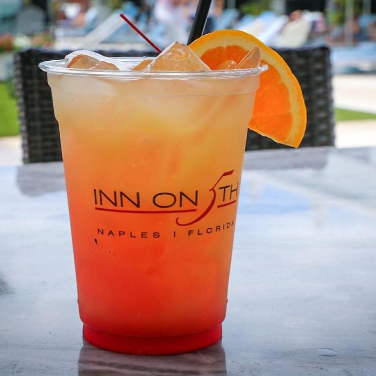 a drink sitting on a table with an orange slice at Inn On Fifth in Naples