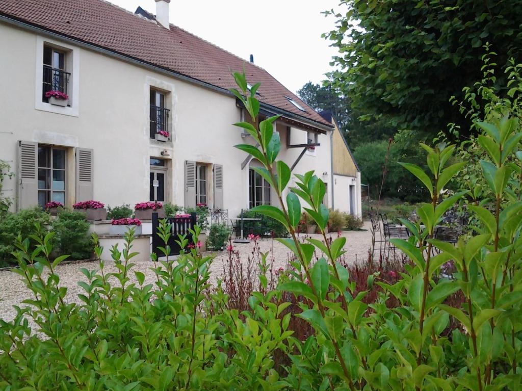 een wit huis met planten ervoor bij Le Repos Coquelicot in Montillot