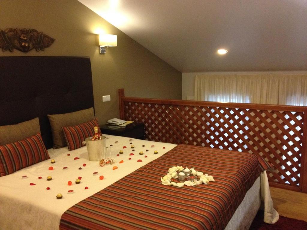 um quarto com uma cama com pétalas de flores em Hotel Katia em Chaves