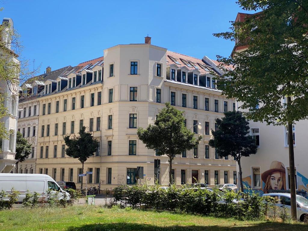 Hotel 3-Room Karl-Heine, a large building with cars parked in front of it at 3-Room Karl-Heine in Leipzig