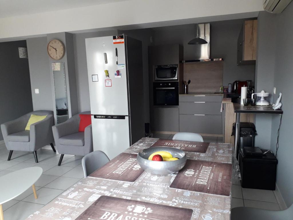 une cuisine avec une table avec un bol de fruits dessus dans l'établissement Appartement village Le Liberty 3 Argelès Sur Mer 2km plage, à Argelès-sur-Mer