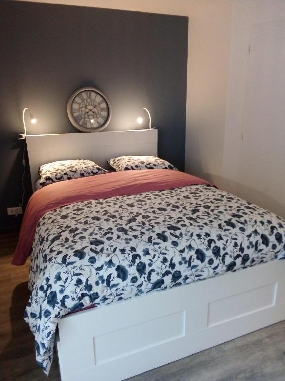 une chambre avec un lit avec une couette bleue et blanche dans l'établissement le Voili Voilou studio climatisé, à Sète