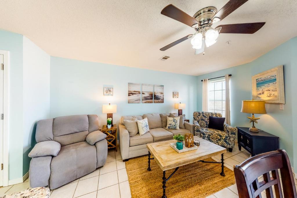 a living room with a couch and a ceiling fan at Grand Beach Resort in Gulf Shores