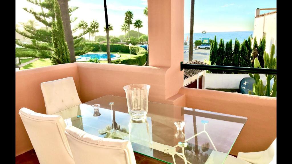 a dining room with a glass table and white chairs at MARBELLA ALICATE BEACHFRONT - Luxury Apartment-1 in Marbella