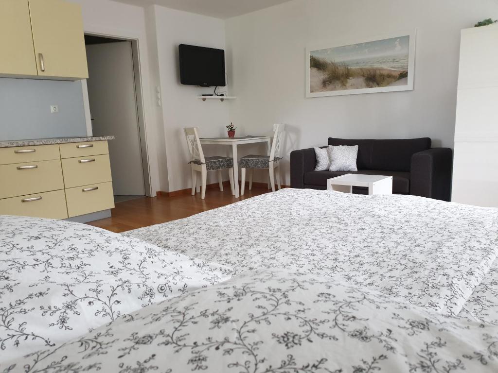 a bedroom with a bed and a couch and a table at Studio EMMA Ljubljana - FREE parking, AC, Wifi in Ljubljana
