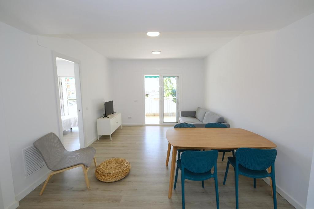 a living room with a dining room table and chairs at Apartaments Àlex in Cambrils