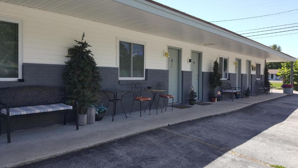 a porch of a house with chairs and tables at Bear Cove Inn in Saint Ignace