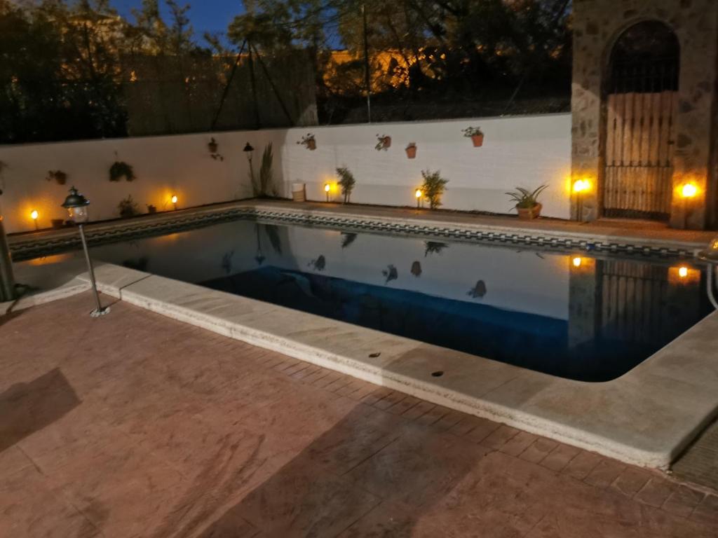 a swimming pool at night with lights in it at Entre pinos y playa in Matalascañas