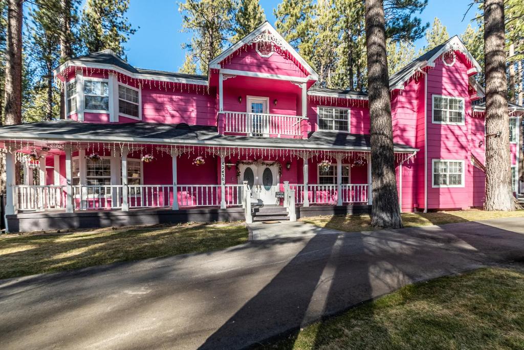 uma casa cor-de-rosa com uma árvore em frente em Apples Bed and Breakfast Inn em Big Bear Lake