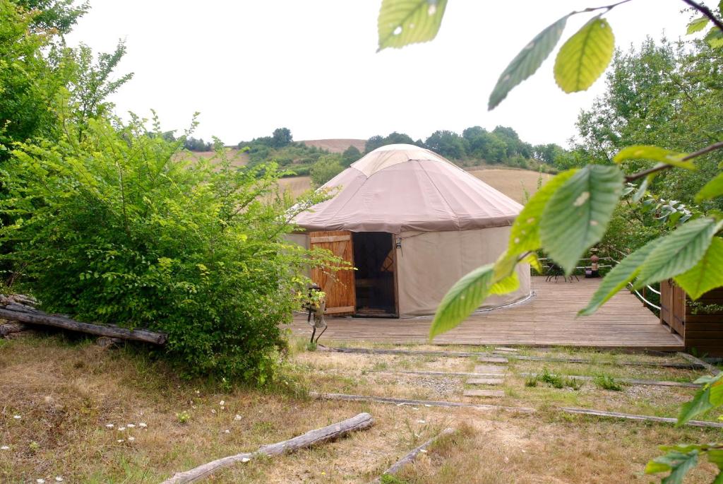 Saint-Urcisse的住宿－le cri de la yourte，圆顶帐篷,在田野上设有木甲板