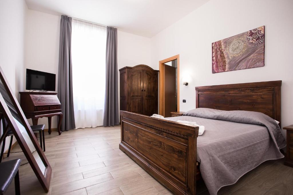 ein Schlafzimmer mit einem Bett, einem TV und einem Klavier in der Unterkunft Hotel Amico in Mailand