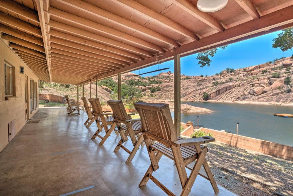 a row of chairs on a porch with a view of the water at Rustic and Western House on Lake - Swim, Fish, Hunt! in Llano
