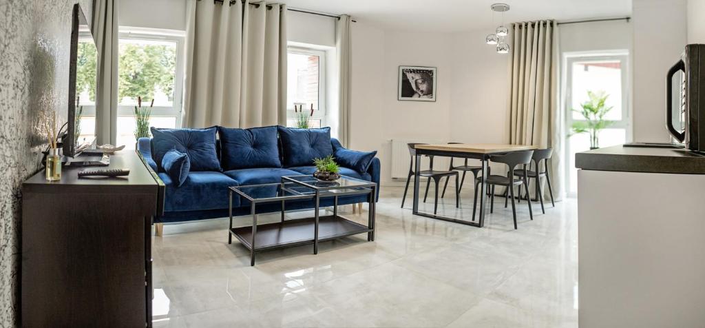 uma sala de estar com um sofá azul e uma mesa em Corso No 7 APARTMENT em Szczawno-Zdrój