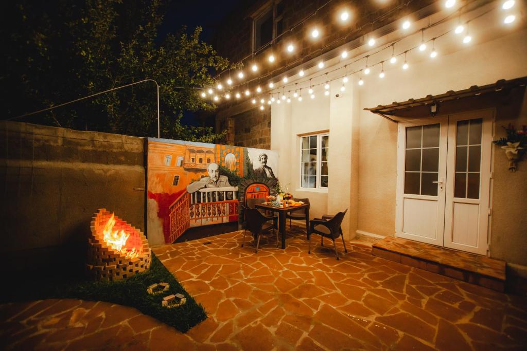 a patio with a fireplace and a table and lights at Mkhitaryan Guest House in Gyumri