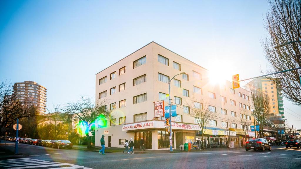 a building on a city street with a traffic light at English Bay Hotel in Vancouver