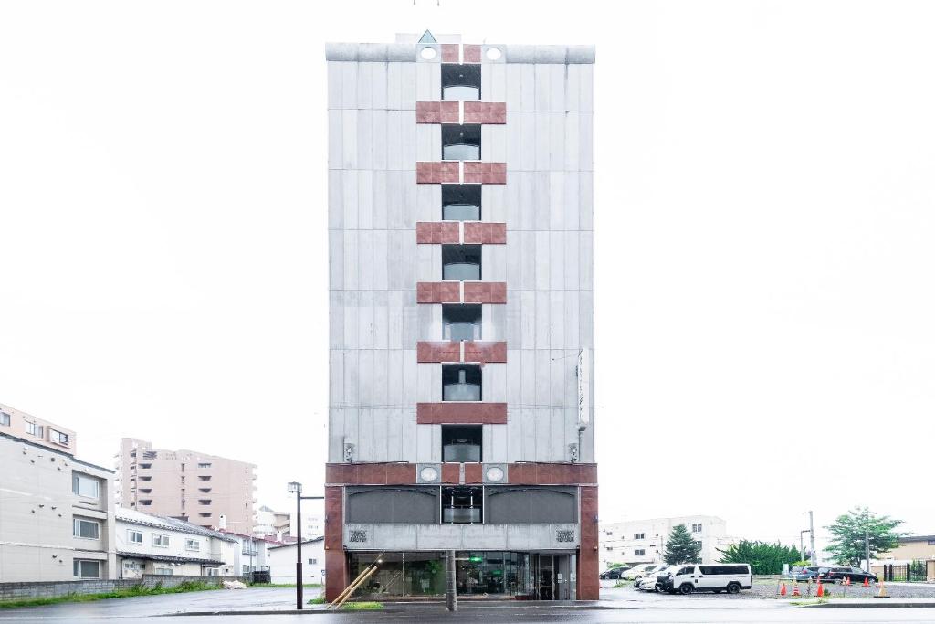 a tall white building with red bricks at Tabist Annex Hotel Tetora Hakodate in Hakodate