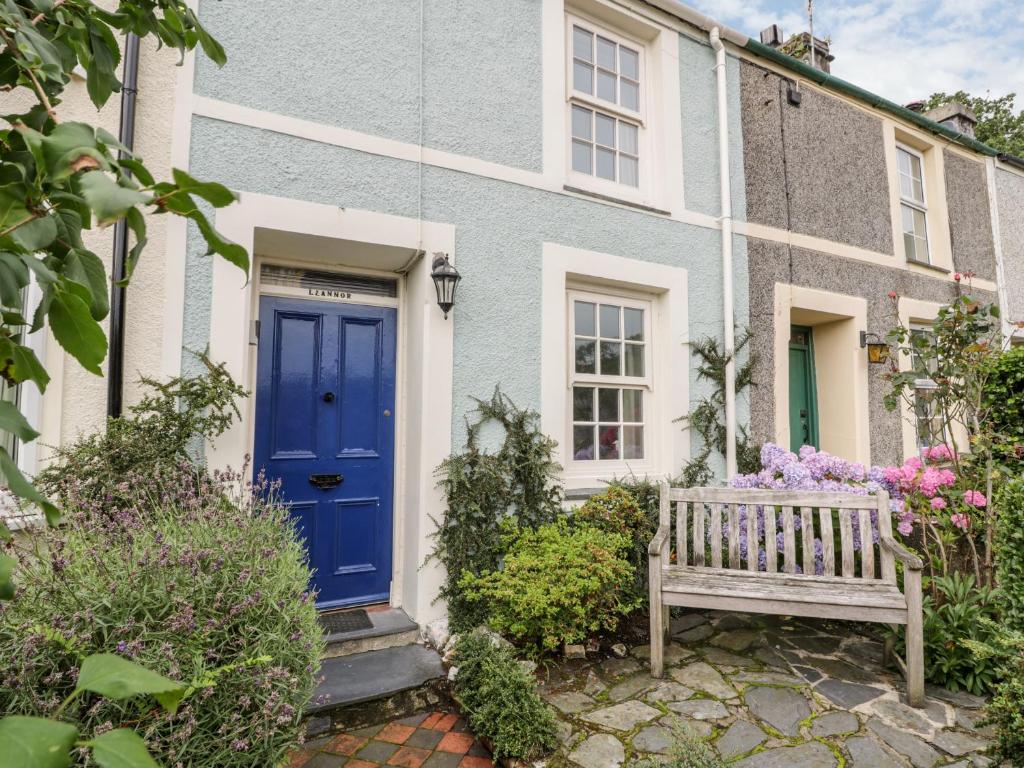 una porta blu su una casa con una panchina di Llannor a Porthmadog