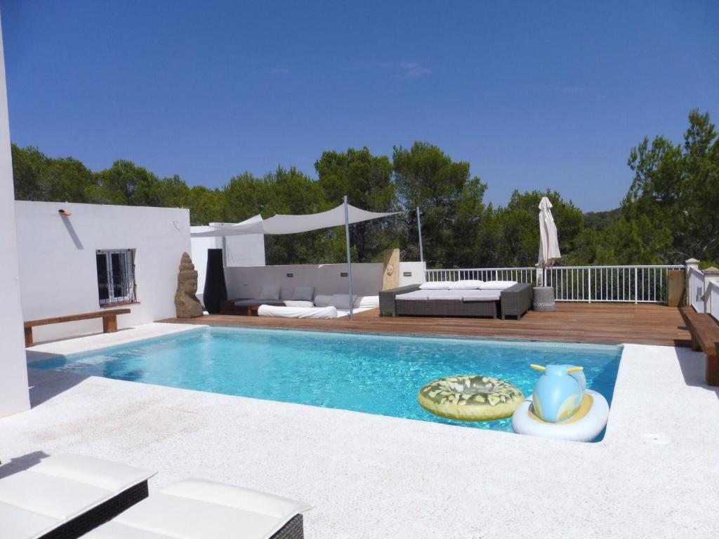 einen Pool mit einem Sofa und einem Tisch in der Unterkunft Belvilla by OYO Casa Loma in Cala Tarida