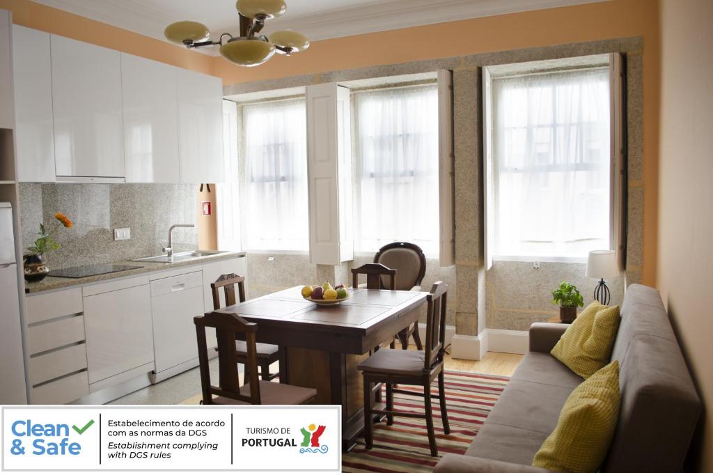 een keuken en eetkamer met een tafel en een bank bij Porto.arte guest apartments in Porto